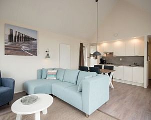 Open living space in VUURTORENLODGE 4, Hollum, Ameland with kitchen, sitting area and dining area in a modern style.