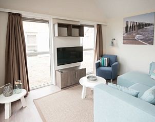 Gezellige woonkamer van VUURTORENLODGE 6 in Hollum, Ameland met moderne inrichting en veel natuurlijk licht.