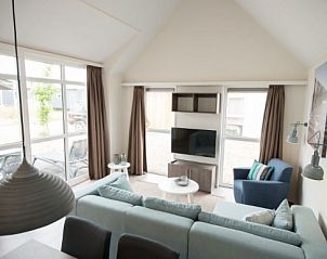 Lichte leefruimte in VUURTORENLODGE 6, vakantieverblijf in Hollum, Ameland met grote ramen en moderne inrichting.