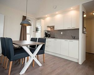 Moderne keuken in AMELANDLODGE 4, vakantiehuis in Hollum, Ameland, met eethoek en strakke witte kasten voor een comfortabele maaltijdervaring.