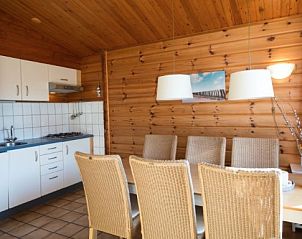 Eetkamer en keuken van FINSE BUNGALOW 4 in Hollum, Ameland, met houten interieur en moderne voorzieningen.