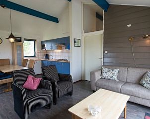 Gezellige woonkamer van BORNRIF COTTAGE DELUXE 4 in Hollum, Ameland, met comfortabele zithoek en moderne keuken.