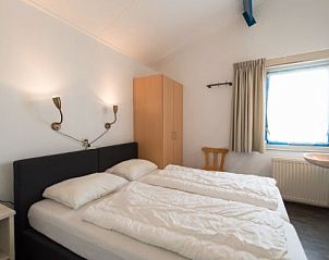 Slaapkamer in BORNRIF COTTAGE DELUXE 4, Hollum, Ameland, met comfortabele bedden en rustgevende inrichting.