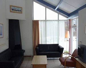 Gezellige woonkamer van DUINVILLA 6 in Hollum, Ameland, met comfortabele zithoek en veel natuurlijk licht.