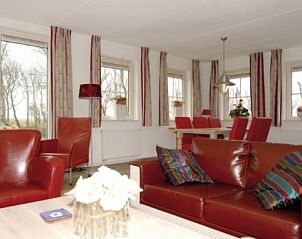 Gezellige woonkamer van WEIDEVILLA B 6 in Hollum, Ameland, met comfortabele zitruimte en eetgedeelte.