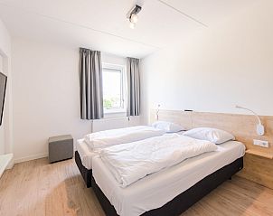 Sfeervolle slaapkamer in Duinbungalow Luxe 10, Hollum, Ameland. Geniet van comfort en rust op de Waddeneilanden in deze luxe vakantieaccommodatie.