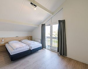 Lichte slaapkamer in Duinbungalow Luxe 10, Hollum, Ameland met comfortabel bed en uitzicht op de natuur van de Waddeneilanden.