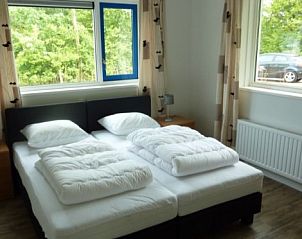 Comfortabele slaapkamer in VIJVERWONING 4, vakantiehuis in Hollum, Ameland, met uitzicht op de groene omgeving van de Waddeneilanden.