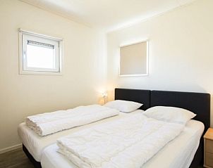 Sfeervolle slaapkamer in BRANDING 4 vakantiehuis, Hollum, Ameland met comfortabele bedden voor een goede nachtrust.