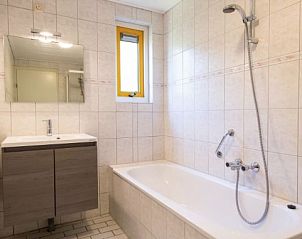 Gerumiges Badezimmer mit Badewanne im DUINBUNGALOW 6, Hollum, Ameland, fr ultimative Entspannung auf den Watteninseln.