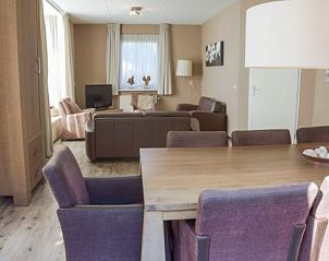 Gezellige binnenruimte van DUINBUNGALOW 10 in Hollum, Ameland, met comfortabele zithoek en veel natuurlijk licht.