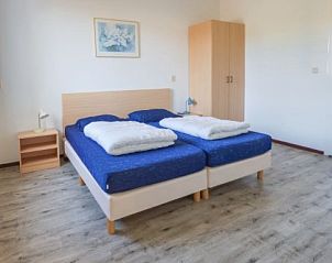Lichte slaapkamer in DUINBUNGALOW 10, Hollum, Ameland, met comfortabele bedden en moderne inrichting voor een ontspannen verblijf.