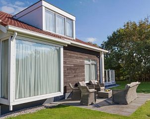 Buitenterras van DUINBUNGALOW 10 in Hollum, Ameland, omgeven door natuur, perfect voor ontspanning en buitenactiviteiten.