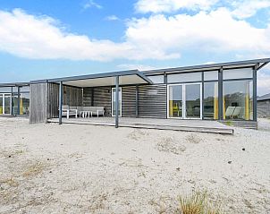 Vrijstaande vakantiewoning in Hollum, Ameland met grote glazen ramen en een uitnodigende veranda op de Waddeneilanden.