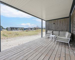Zonnige veranda van de vrijstaande woning in Hollum, Ameland, perfect voor buiten ontspanning op de Waddeneilanden.