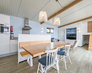 Gezellige eetruimte met houten tafel in vakantiewoning Hollum, Ameland.
