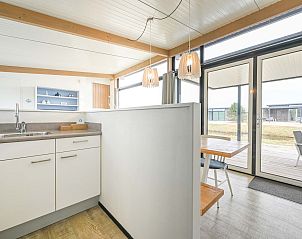 Strakke keuken met uitzicht op terras in vakantiewoning Hollum, Ameland.