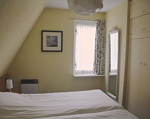 Knusse slaapkamer met natuurlijk licht in Appartement Amelander Kaap 2, Hollum, Ameland voor een rustgevende nachtrust.