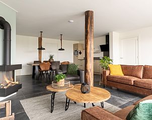 Open leefruimte in vakantiehuis Langsdeel, Hollum, Ameland met gezellige zithoek en haard.