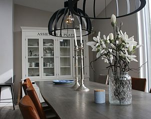 Stijlvol ingerichte eetkamer in bungalow Duyngolf 12, Hollum, Ameland. Gezellige sfeer met moderne verlichting en uitzicht op de natuur.