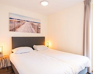 Gezellige slaapkamer met kunst aan de muur in Waddenlodge 8, gelegen in Hollum, Ameland.