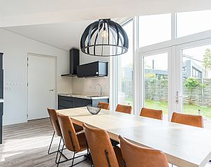 Lichte woonkamer in Duyngolf 8, een bungalow in Hollum, Ameland. Moderne inrichting met ruime eethoek en comfortabele zithoek.