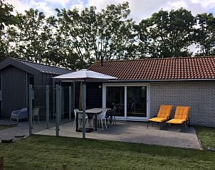 Ontspan op het terras van Bornrif Luxe 6, een moderne bungalow in Hollum, Ameland, omringd door weelderige natuur op de Waddeneilanden.