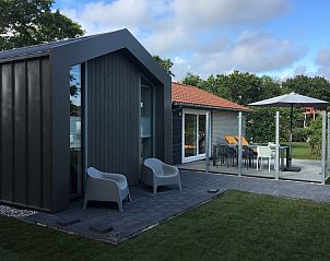 Bornrif Luxe 6 bungalow in Hollum, Ameland met modern terras en comfortabele zitplaatsen, omgeven door groene natuur op de Waddeneilanden.