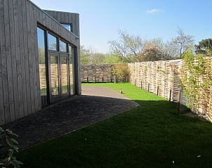 Zonnig terras bij Duyngolf 71 vakantiehuis in Hollum Ameland, met uitzicht op de tuin.