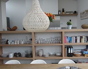 Stijlvolle eetkamer in Duyngolf 71 vakantiehuis Hollum Ameland met open kast en decoratieve lamp.