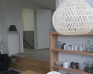 Ruime eetruimte in Duyngolf 71 vakantiehuis Hollum Ameland met houten eettafel en designlamp.