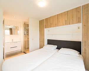 Moderne badkamer in Waddenlodge 6+2, een vakantiehuis in Hollum, Ameland, met strakke witte tegels en stijlvolle inrichting.