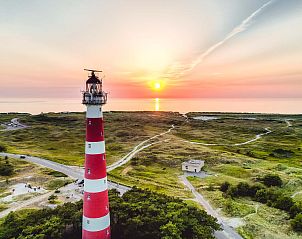 Iconische vuurtoren bij zonsondergang, dichtbij de vrijstaande woning in Hollum, Ameland, Waddeneilanden.