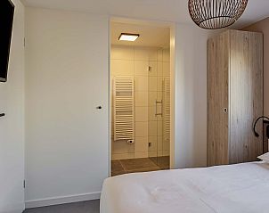 Slaapkamer met moderne badkamer in Vrijstaande woning in Hollum, Ameland, vakantiehuis op de Waddeneilanden.