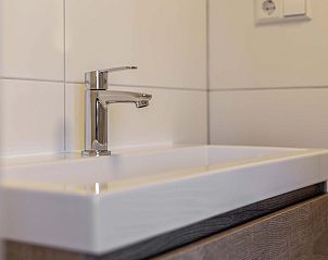 Stijlvolle wastafel in Vrijstaande woning in Hollum, Ameland, vakantiehuis met moderne badkamer op de Waddeneilanden.