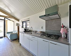 Open keuken in de vrijstaande woning in Hollum, Ameland, voorzien van moderne apparatuur en veel licht.