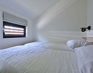 Gezellige tweede slaapkamer in de vrijstaande woning in Hollum, Ameland, met uitzicht op de omgeving.