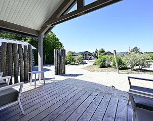 Uitzicht vanaf de veranda van de vrijstaande woning in Hollum, Ameland, met zicht op de natuurlijke omgeving.