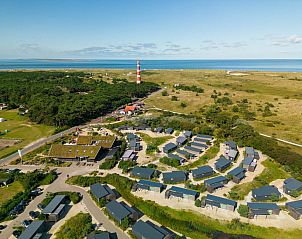 Luchtfoto van de omgeving van de vrijstaande woning in Hollum, Ameland, met zicht op de duinen en zee.