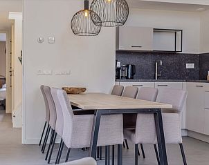 Eethoek naast de keuken in de Vrijstaande woning in Hollum, Ameland, met houten tafel.