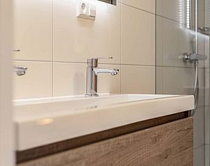 Trap naar bovenverdieping in de Vrijstaande woning in Hollum, Ameland, met houten leuning.