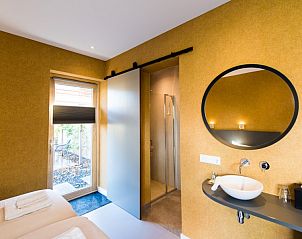 Compacte badkamer in Breeze 1 appartement, Hollum, Ameland met moderne voorzieningen en toegang tot terras.