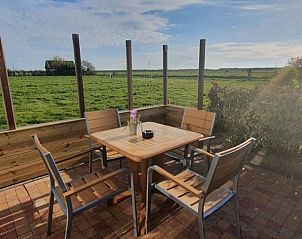 Zonnig terras bij Ilsebil vakantiehuis in Hollum, Ameland, met prachtig uitzicht op de natuur.