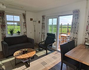 Woonkamer en eetgedeelte in Ilsebil vakantiehuis, Hollum, Ameland, met toegang tot terras.