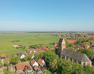 Luchtfoto van Hollum, Ameland met Ilsebil vakantiehuis en weids uitzicht over de Waddeneilanden.