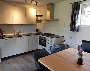 Moderne keuken in vakantiehuis Piggelmee, Hollum, Ameland, met eethoek en apparatuur.