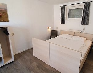 Ruime slaapkamer met tweepersoonsbed in vakantiehuis Piggelmee, Hollum, Ameland.