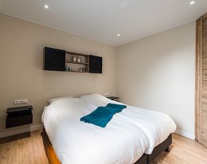 Knusse slaapkamer in Daalders plakje appartement in Hollum, Ameland met comfortabel bed en rustgevende sfeer.