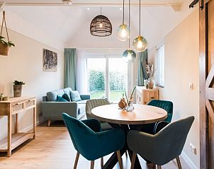 Eethoek in Daalders plakje appartement in Hollum, Ameland met stijlvolle verlichting en comfortabele stoelen.