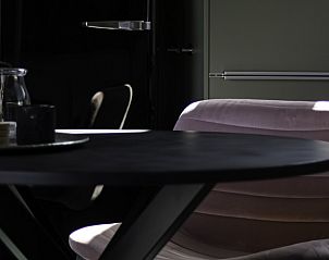 Moderne zitruimte in appartement De Hoge Stoep, Hollum, Ameland met elegante details en warme sfeer.